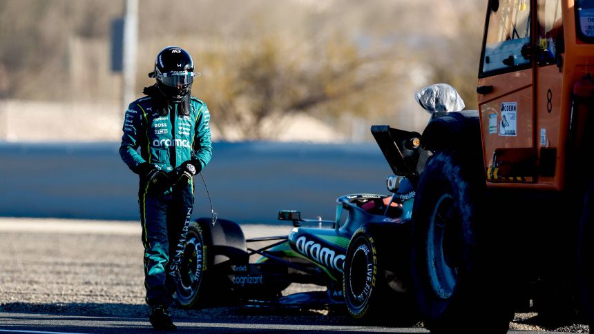 Piloto de Aston Martin junto a su monoplaza en los test