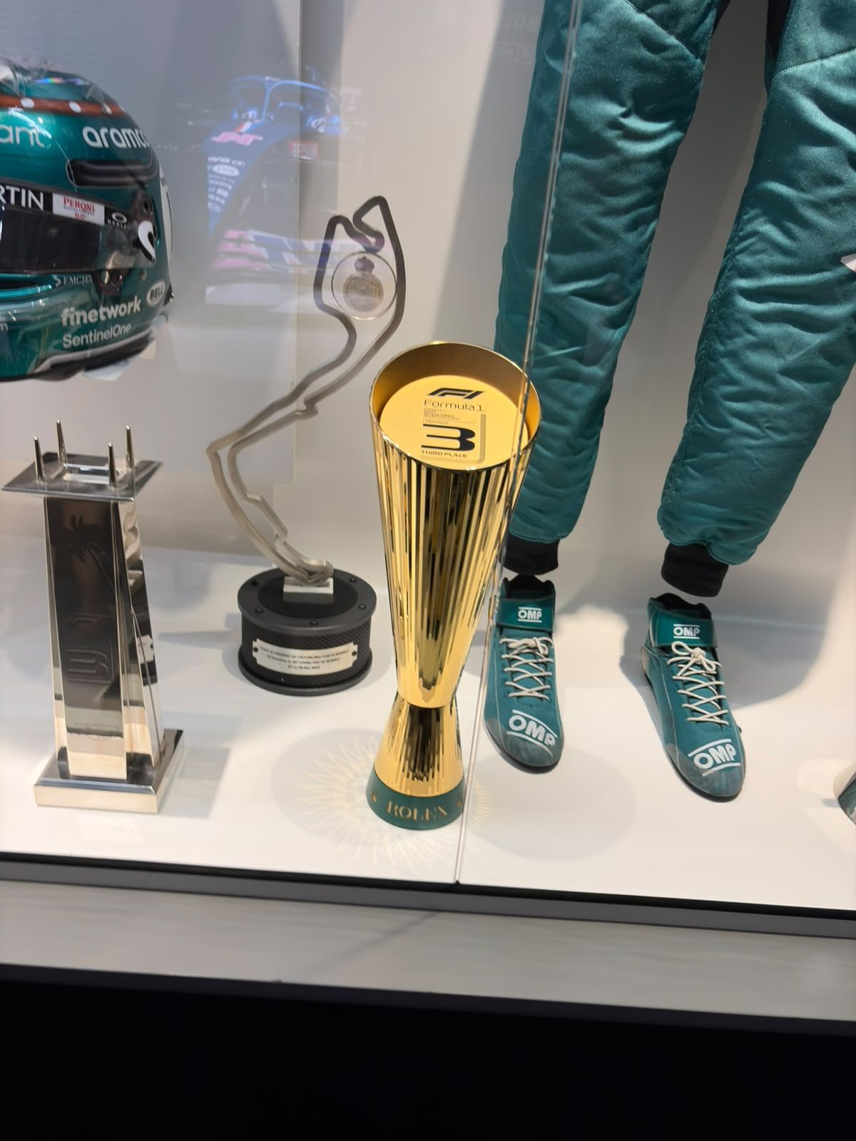 Trofeo de tercer puesto, réplica de Mónaco y equipación de Aston Martin